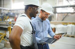 Two workers at a factory for the production of plastic windows. Engineer and worker on the production line photo