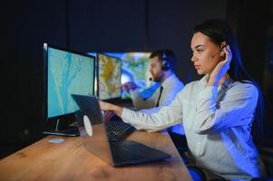 Center of dispatching maintenance. Portrait of cheerful woman and man working via headset microphone while sitting on navigation controller board photo