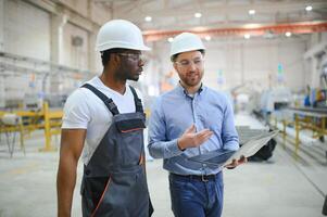 Two workers at a factory for the production of plastic windows. Engineer and worker on the production line photo
