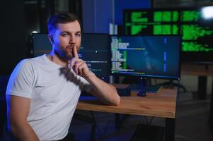 Male programmer working on desktop computer at white desk in office photo