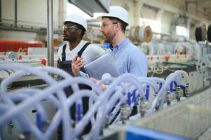 Two workers at a factory for the production of plastic windows. Engineer and worker on the production line photo