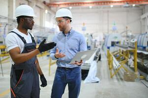 Two workers at a factory for the production of plastic windows. Engineer and worker on the production line photo