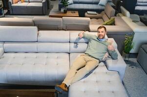 Man in furniture store choosing sofa photo