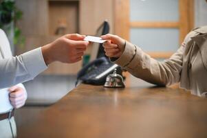 Close up of hand guest takes room key at check-in desk of the hotel. Hotel concept photo