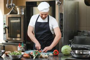 Chef cook in uniform cooking in the big cooker at the restaurant kitchen photo