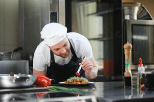 Chef cook in uniform cooking in the big cooker at the restaurant kitchen photo