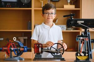 Physics lesson. A student at a desk with scientific instruments and a telescope photo