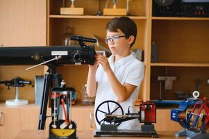 Physics lesson. A student at a desk with scientific instruments and a telescope photo