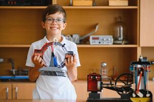 Physics lesson. A student at a desk with scientific instruments and a telescope photo