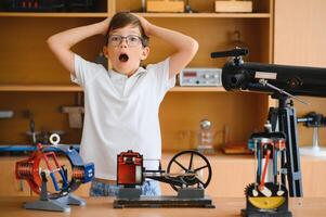 Physics lesson. A student at a desk with scientific instruments and a telescope photo