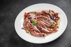 anchovies in a plate on the table canned fish in oil fresh and tasty seafood meal food snack on the table copy space food background rustic photo