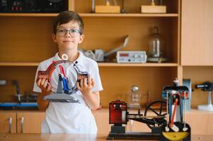 Physics lesson. A student at a desk with scientific instruments and a telescope photo