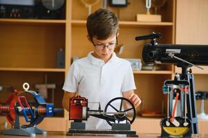Physics lesson. A student at a desk with scientific instruments and a telescope photo