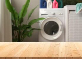 Wood table for display products on background of blurred laundry room photo