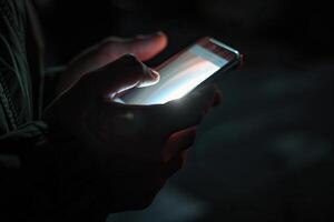 Bright light from a smartphone in a man's hands in the dark. Generated by artificial intelligence photo