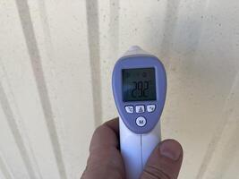 Measuring temperature with a non-contact thermometer photo