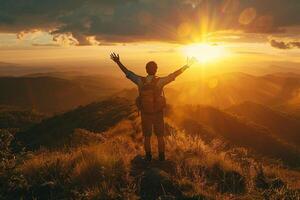 Silhouette of a man standing on top of a mountain. A man stands on a cliff at sunset or dawn. Concept of sport, adventure, success, lifestyle. photo