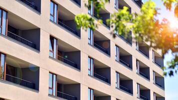 New modern block of flats in green area. Eco apartment building saving energy and fresh air concept. Green tree and new apartment building. The harmony of nature and modernity. photo