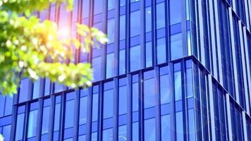 City life, urban landscape and ecology. Modern office complex with glass facades and smooth lines against backdrop of green trees, concept of modern architecture. Organically building into nature. photo
