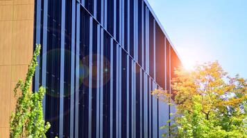 City life, urban landscape and ecology. Modern office complex with glass facades and smooth lines against backdrop of green trees, concept of modern architecture. Organically building into nature. photo