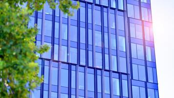City life, urban landscape and ecology. Modern office complex with glass facades and smooth lines against backdrop of green trees, concept of modern architecture. Organically building into nature. photo