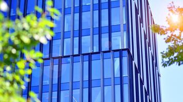 City life, urban landscape and ecology. Modern office complex with glass facades and smooth lines against backdrop of green trees, concept of modern architecture. Organically building into nature. photo