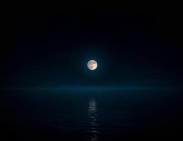 a full moon is seen over the ocean in the serene dark of the night of sharad purnima photo