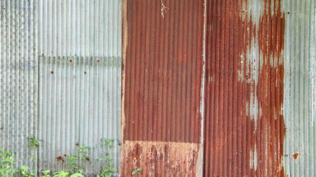 An image of corrugated zinc with rust patches, displaying the textured surface and weathered appearance. photo