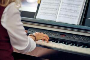 Woman plays electric piano at outdoor music performance, close up view to nimble hands photo