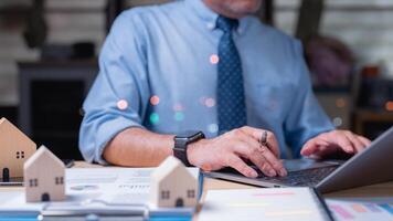 A businessman in a blue shirt and tie is typing on a laptop computer. Concept of professionalism and focus, as the man is likely working on important documents or tasks photo
