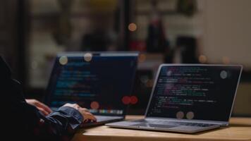 A person is typing coding on a laptop computer with a black screen. The laptop is open to a webpage with a lot of code. The person is focused on the task at hand photo