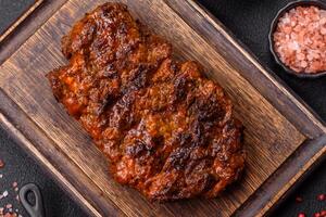 Fresh juicy delicious beef steak on a dark background photo