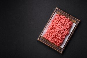 Fresh raw ground beef with salt and spices photo