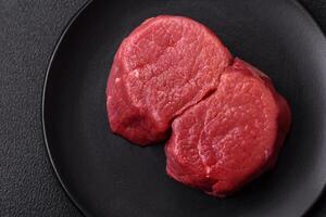 Fresh juicy raw beef medallions with salt and spices photo