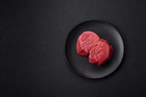 Fresh juicy raw beef medallions with salt and spices photo