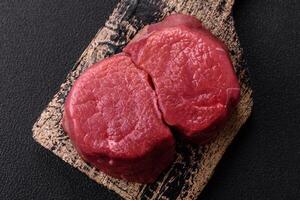 Fresh juicy raw beef medallions with salt and spices photo