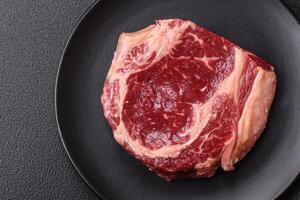 Fresh, raw beef steak with salt, spices and herbs photo