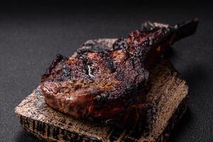 Juicy grilled beef tomahawk steak with salt, spices and herbs photo