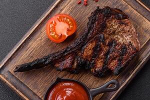 Juicy grilled beef tomahawk steak with salt, spices and herbs photo