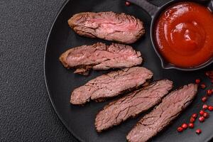 Fresh juicy delicious beef steak on a dark background photo