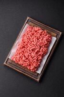 Fresh raw ground beef with salt and spices photo