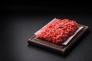 Fresh raw ground beef with salt and spices photo