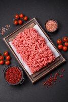 Fresh raw ground beef with salt and spices photo