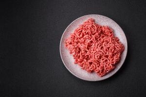 Fresh raw ground beef with salt and spices photo