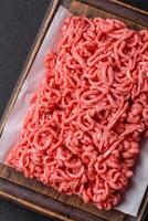 Fresh raw ground beef with salt and spices photo
