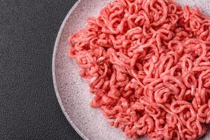 Fresh raw ground beef with salt and spices photo