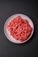 Fresh raw ground beef with salt and spices photo
