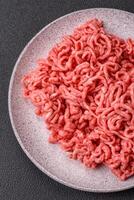 Fresh raw ground beef with salt and spices photo
