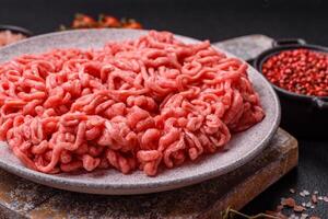 Fresh raw ground beef with salt and spices photo