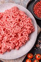 Fresh raw ground beef with salt and spices photo